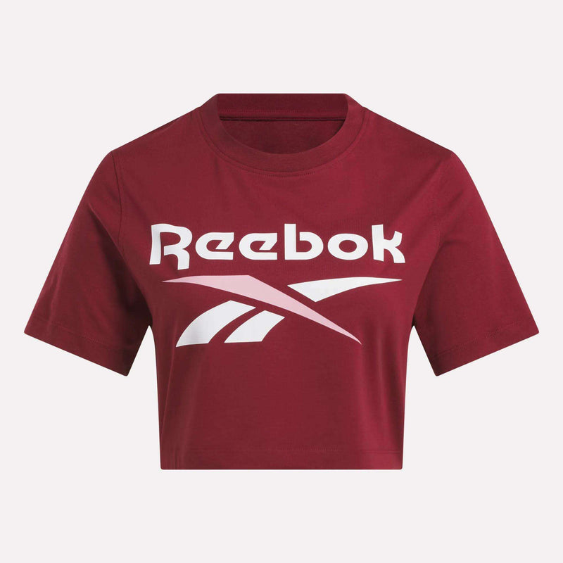 The Reebok Women's Two-Color Logo Crew Cropped Short Sleeve Tee in maroon features a bold white Reebok logo and text across the front.