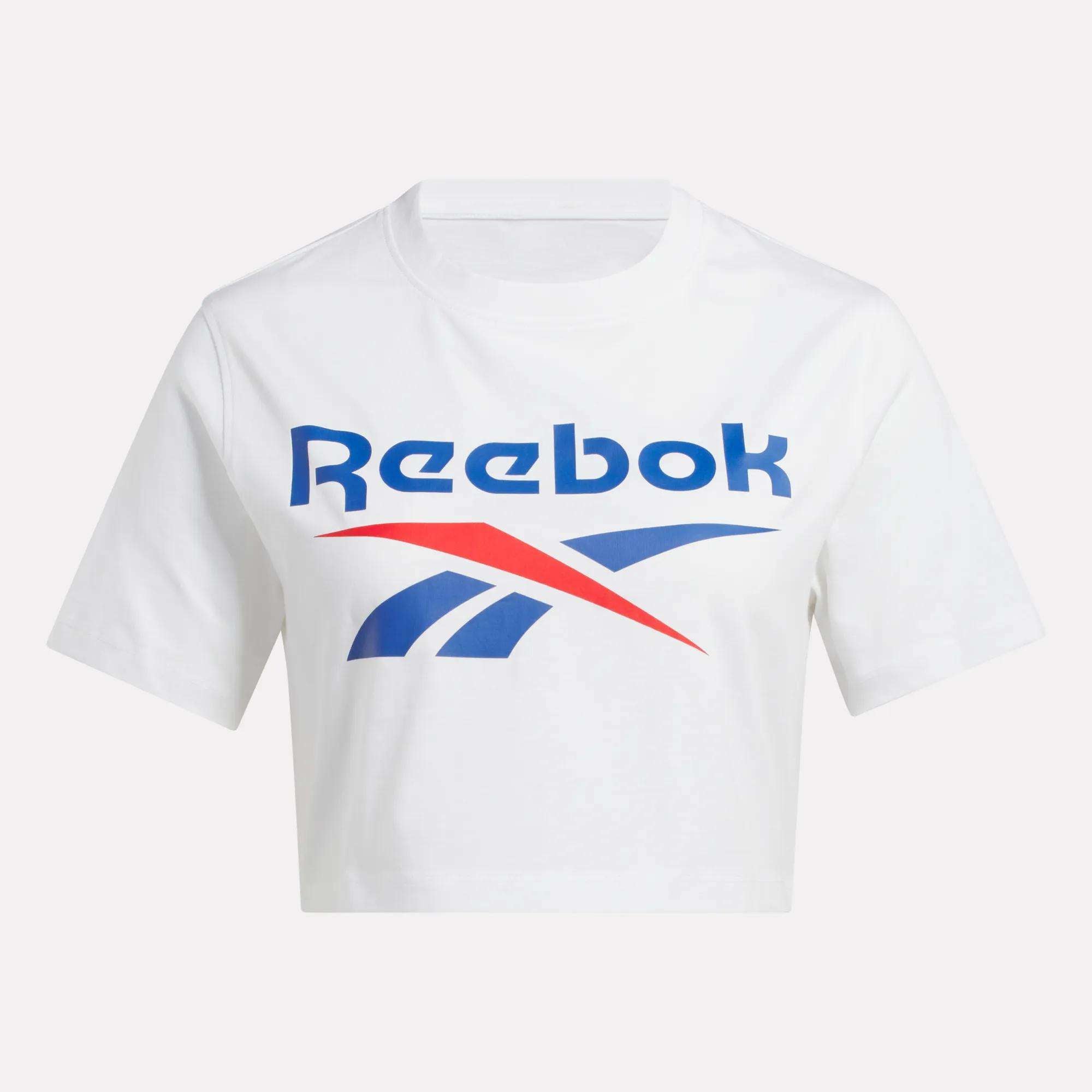 The Reebok Women's Two-Color Logo Crew Cropped Short Sleeve Tee is a white crop top with the bold blue and red Reebok logo printed across the chest.