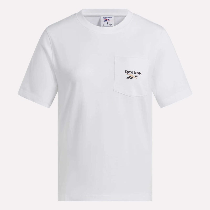 The Reebok Women’s Logo Pocket T-Shirt is a plain white, short-sleeve top with a boxy cropped silhouette. It features a chest pocket on the left side and displays the retro Reebok logo above the pocket.