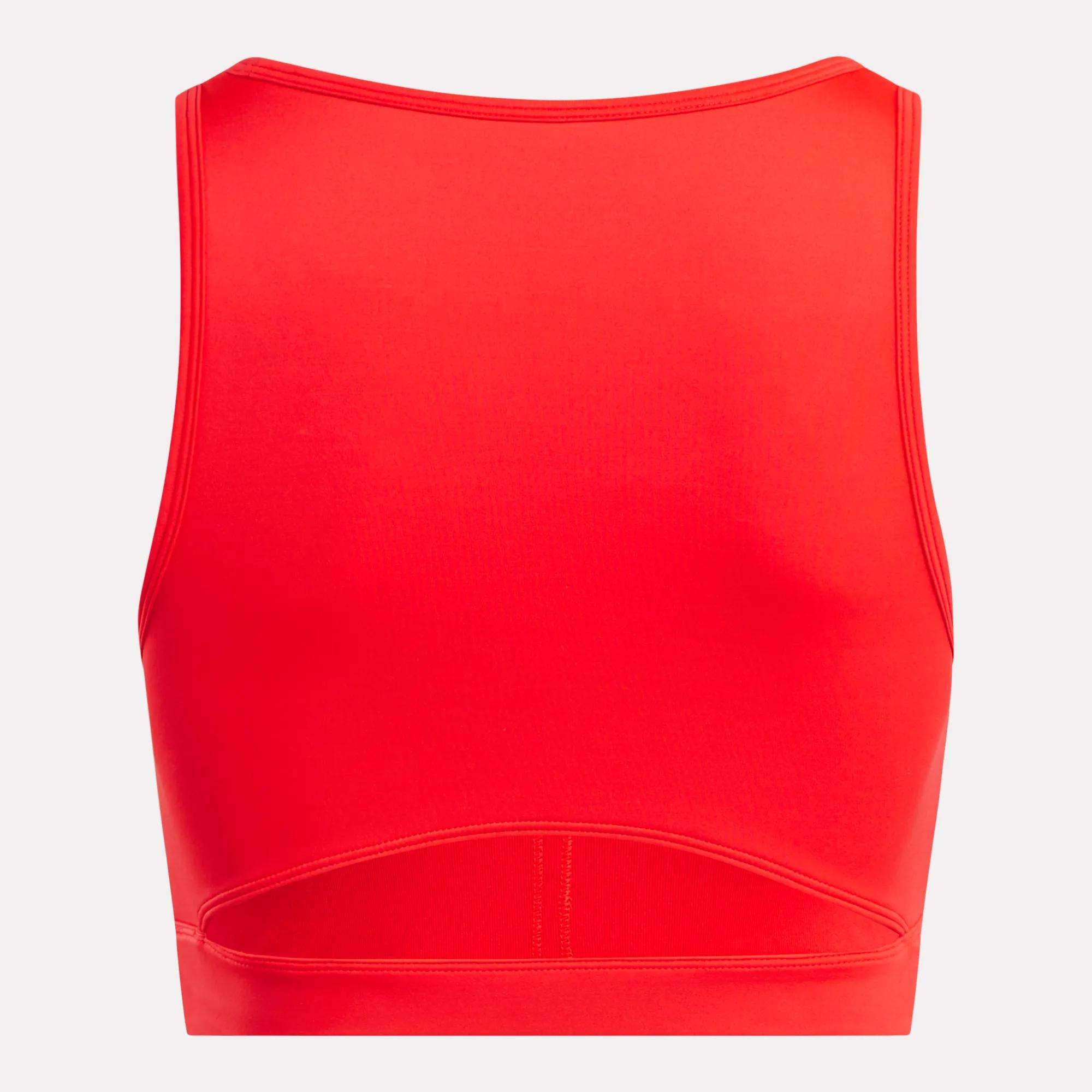 The Reebok Women's Core High-Impact Bra is a bright red crop top with a high neckline and back cutout above the waistband. Made from smooth, stretchy, sweat-wicking fabric, it's ideal for high-impact workouts.
