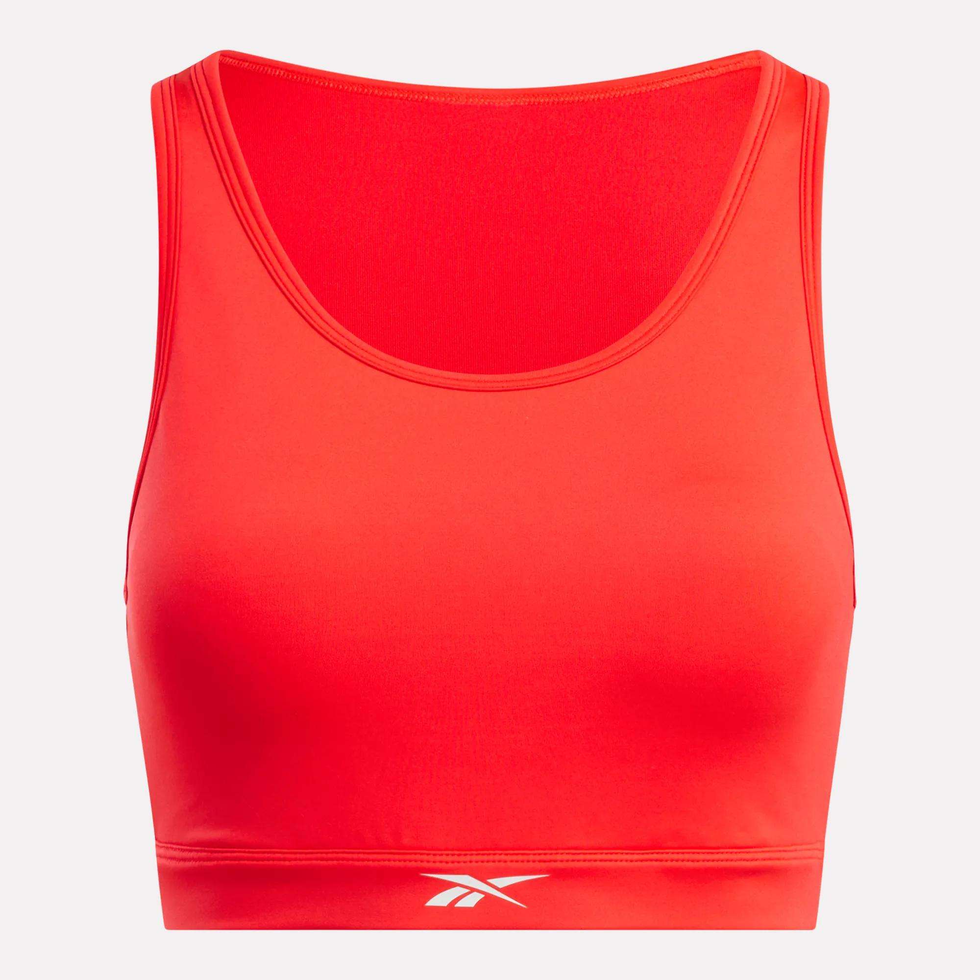 The Reebok Women's Core High-Impact Bra is a bright red, sleeveless crop top with a scoop neckline and white logo at the bottom center. Made from smooth, sweat-wicking, stretchy fabric, it’s perfect for high-impact training.