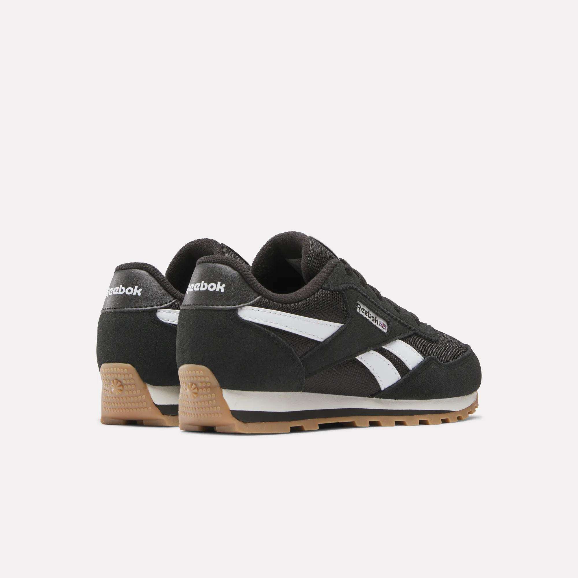 A pair of Reebok Classic AZ Shoes for little kids in black with white accents, foam cushioning, and gum soles, displayed from a rear-side angle on a plain white background.