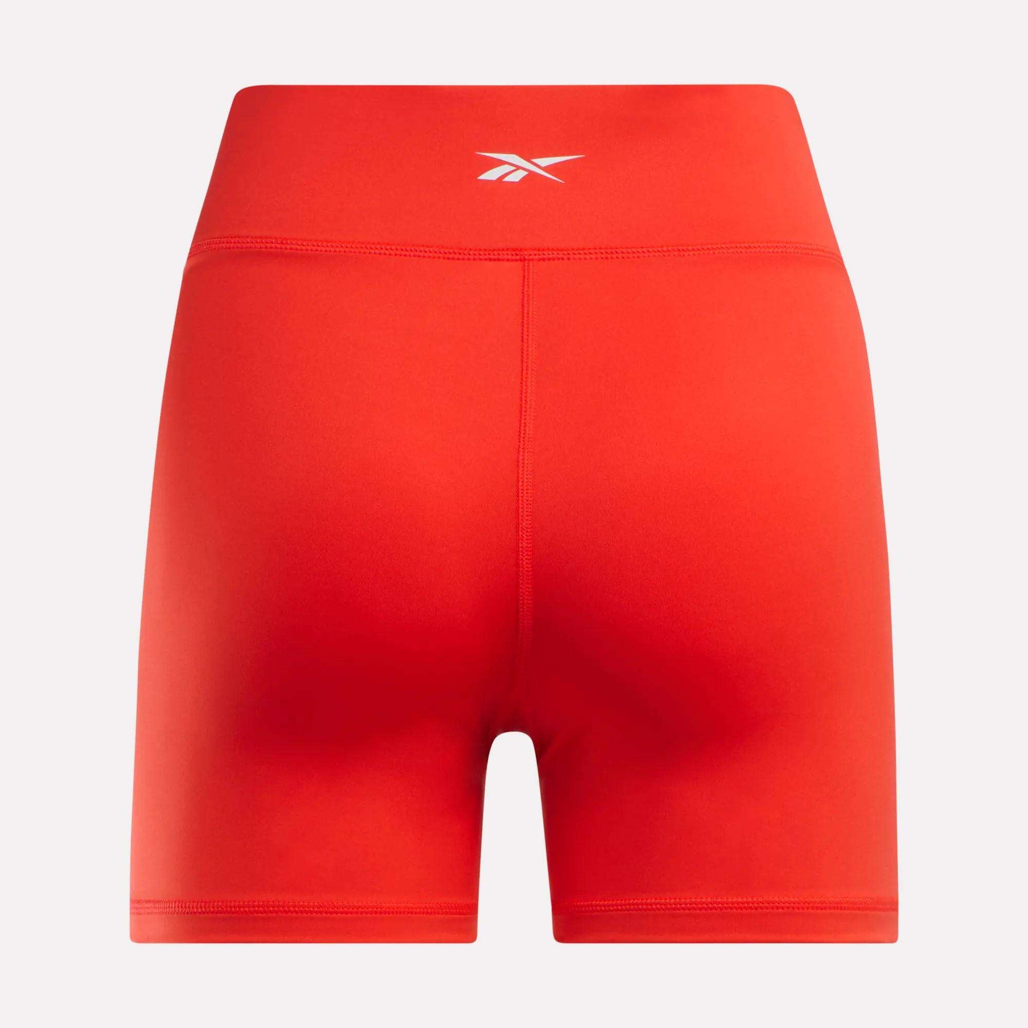 The Women’s Core High-Rise Shorts by Reebok feature a bright red color and a small white Reebok logo centered on the back. Shown against a plain white background.