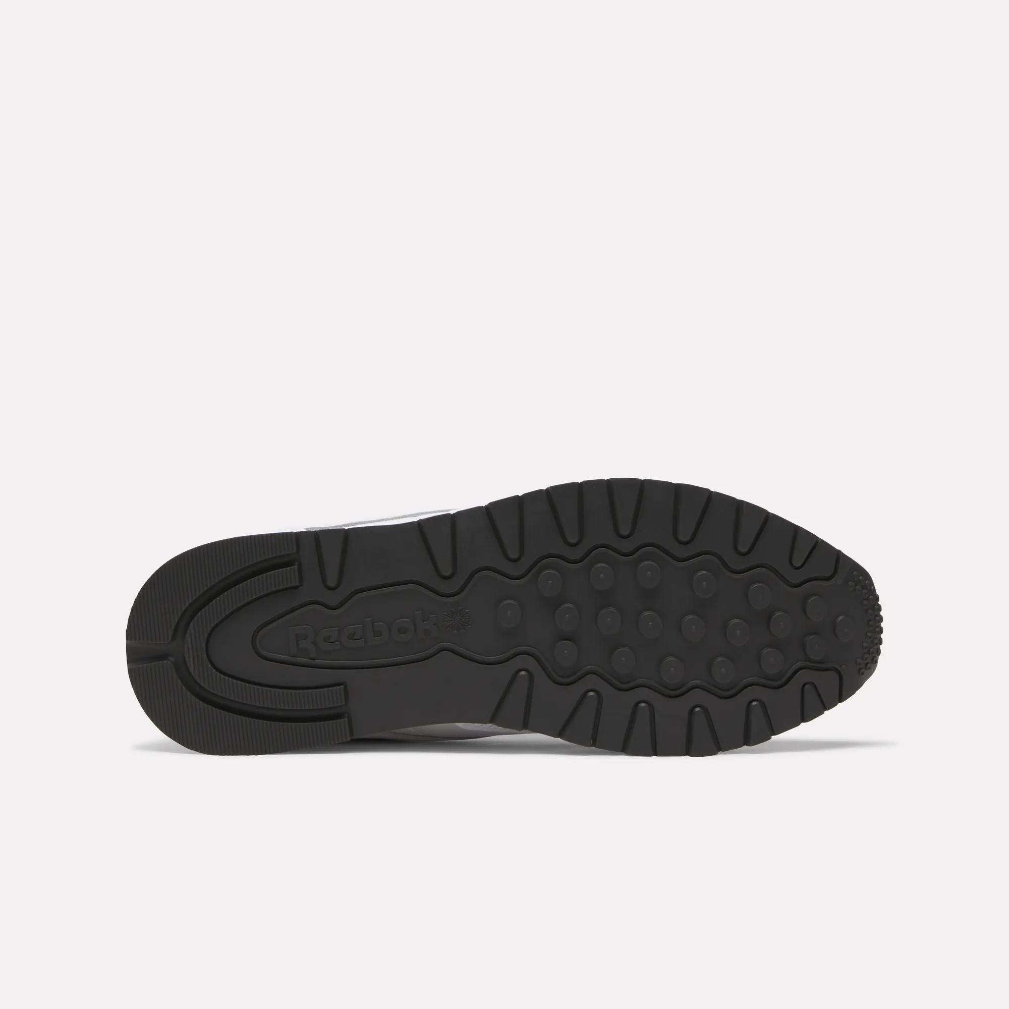 The black rubber sole of Reebok Classic Leather Shoes features a retro running tread with circular grips and the Reebok logo embossed at the midfoot.