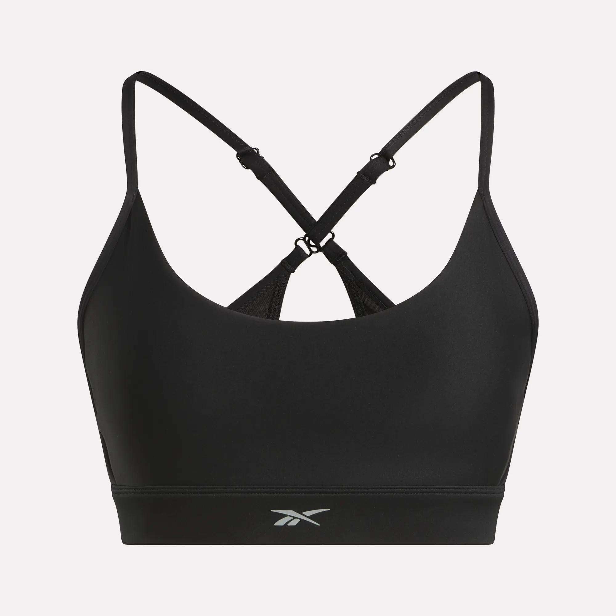 The Reebok Women's Lux Strappy Sports Bra features thin, adjustable crisscross straps, a small front logo, and delivers medium support with sweat-wicking comfort for your workouts.