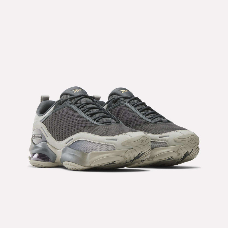 The Reebok DMX Series 3000 Shoes feature dark grey mesh uppers, light grey overlays, chunky soles, and visible heel cushioning with DMX moving air technology for enhanced comfort, shown against a plain light background.