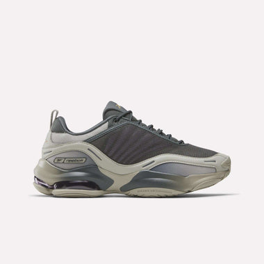 The Reebok DMX Series 3000 Shoes, shown in gray and beige with mesh and synthetic overlays, feature a chunky sole and visible DMX moving air cushioning for comfort. Displayed in a left side profile against a white background.