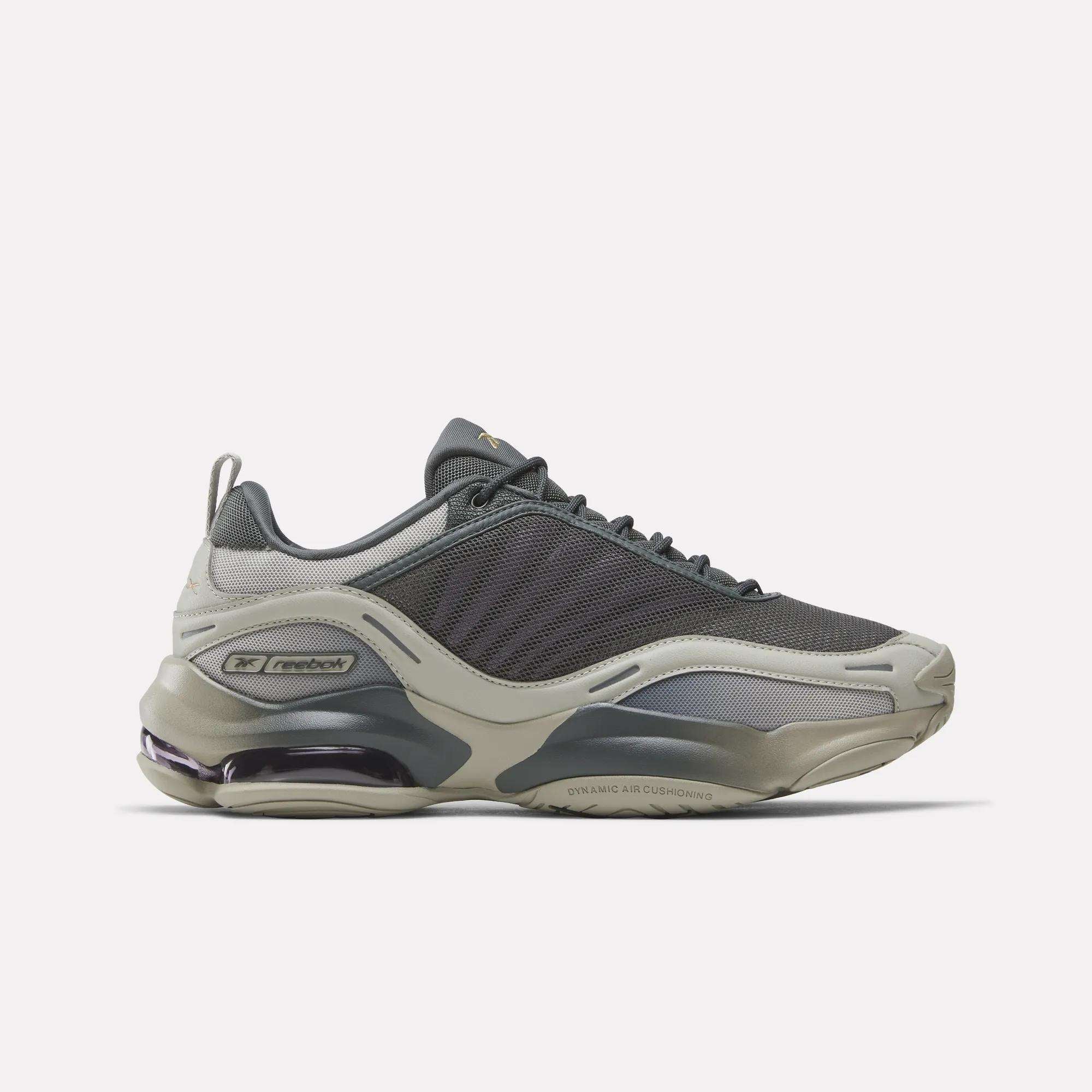 The Reebok DMX Series 3000 Shoes, shown in gray and beige with mesh and synthetic overlays, feature a chunky sole and visible DMX moving air cushioning for comfort. Displayed in a left side profile against a white background.