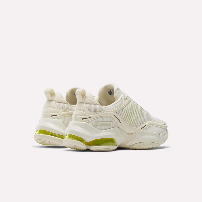 The Reebok Women's DMX Series 3000 Training Shoes are chunky, off-white slip-ons with thick soles and transparent yellow heel accents, delivering style and comfort against a plain light background.