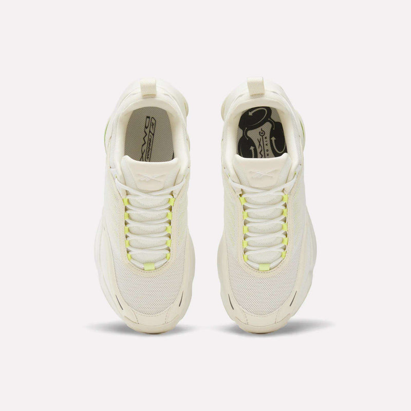 Top view of Reebok Women's DMX Series 3000 Training Shoes in off-white with light yellow laces and mesh upper, side by side on a white background. These cushioned shoes offer ideal comfort for all-day wear.