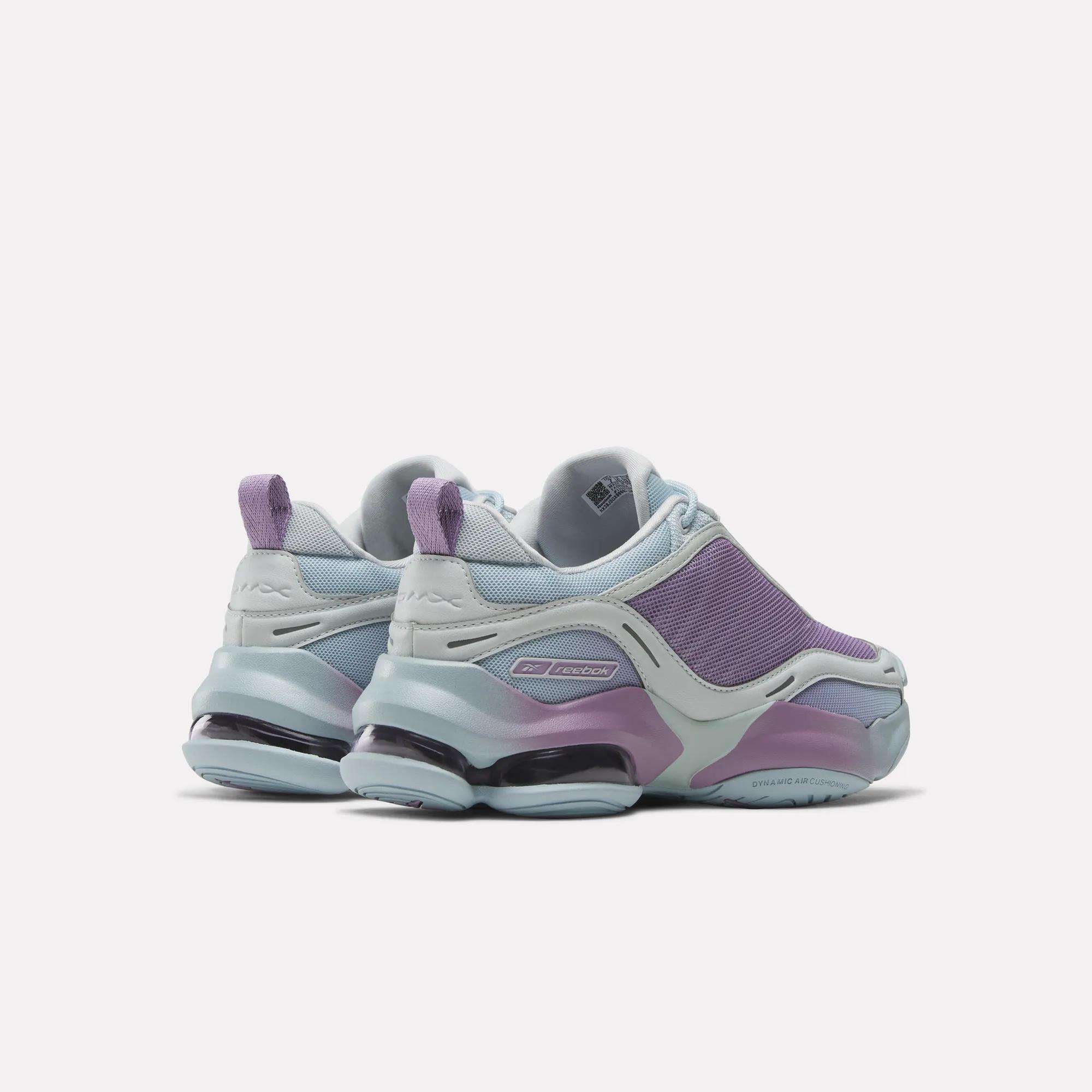 The Reebok Women's DMX Series 3000 Training Shoes feature mesh uppers, chunky soles, cushioned comfort with DMX 3 Technology, and come in modern pastel blue and purple tones, shown from the back at a slight angle.