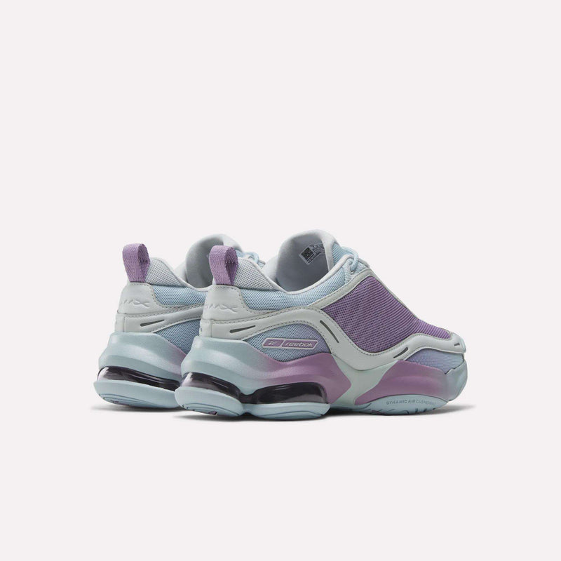 The Reebok Women's DMX Series 3000 Training Shoes feature mesh uppers, chunky soles, cushioned comfort with DMX 3 Technology, and come in modern pastel blue and purple tones, shown from the back at a slight angle.