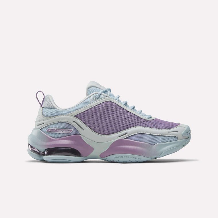 The Reebok Women's DMX Series 3000 Training Shoes feature a stylish light purple and blue mesh upper, smooth overlays, DMX 3 air-cushioned heel, and side Reebok logo for all-day comfort.