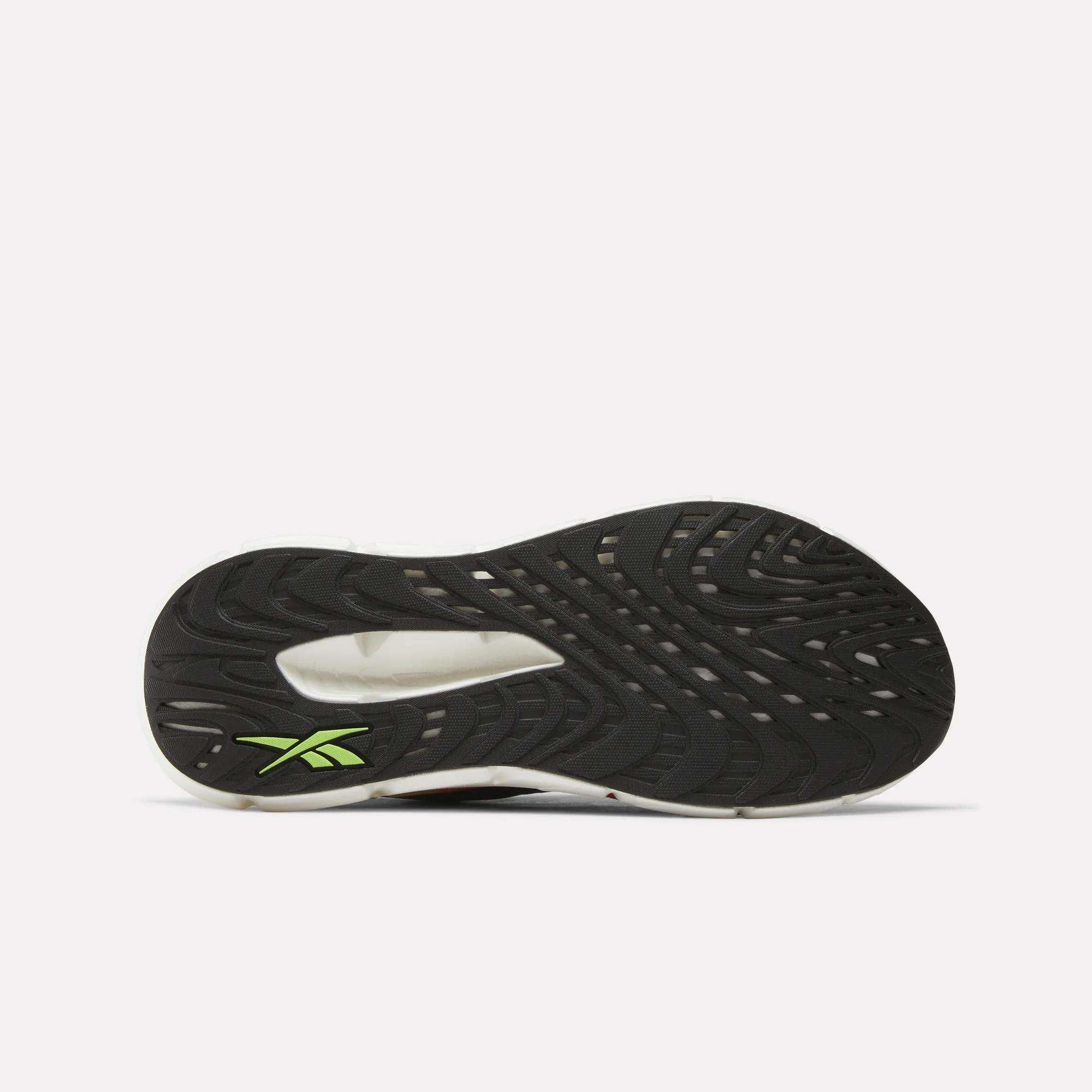 The image displays the black sole of the Men's FloatZig Double Running Shoes by Reebok, featuring a green Reebok logo near the heel and a textured grip pattern, shown on a plain white background.