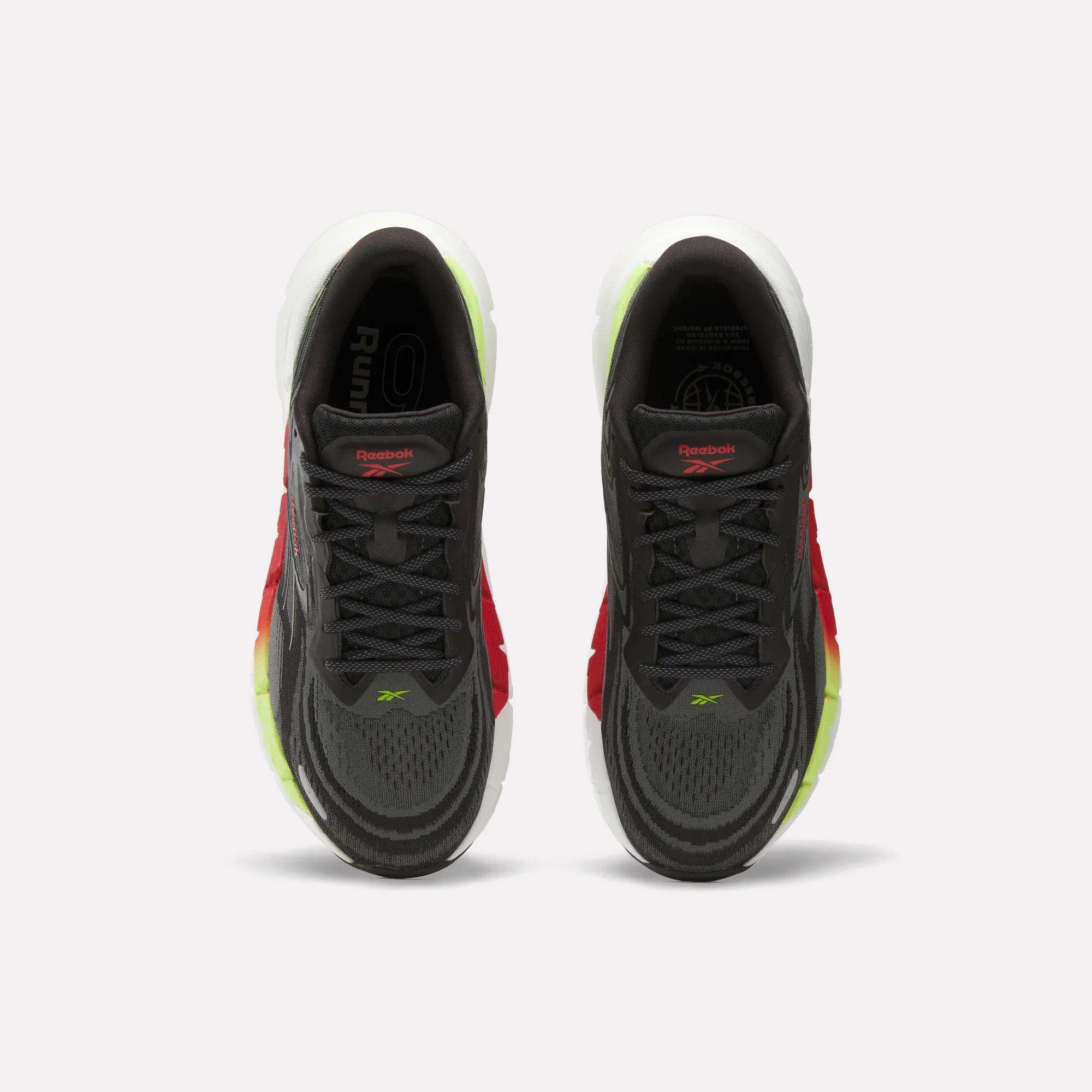 Top view of Reebok Men's FloatZig Double Running Shoes in dark gray with black laces, red side accents, and light green-yellow sole detailing, designed for maximum cushioning, shown on a plain white background.