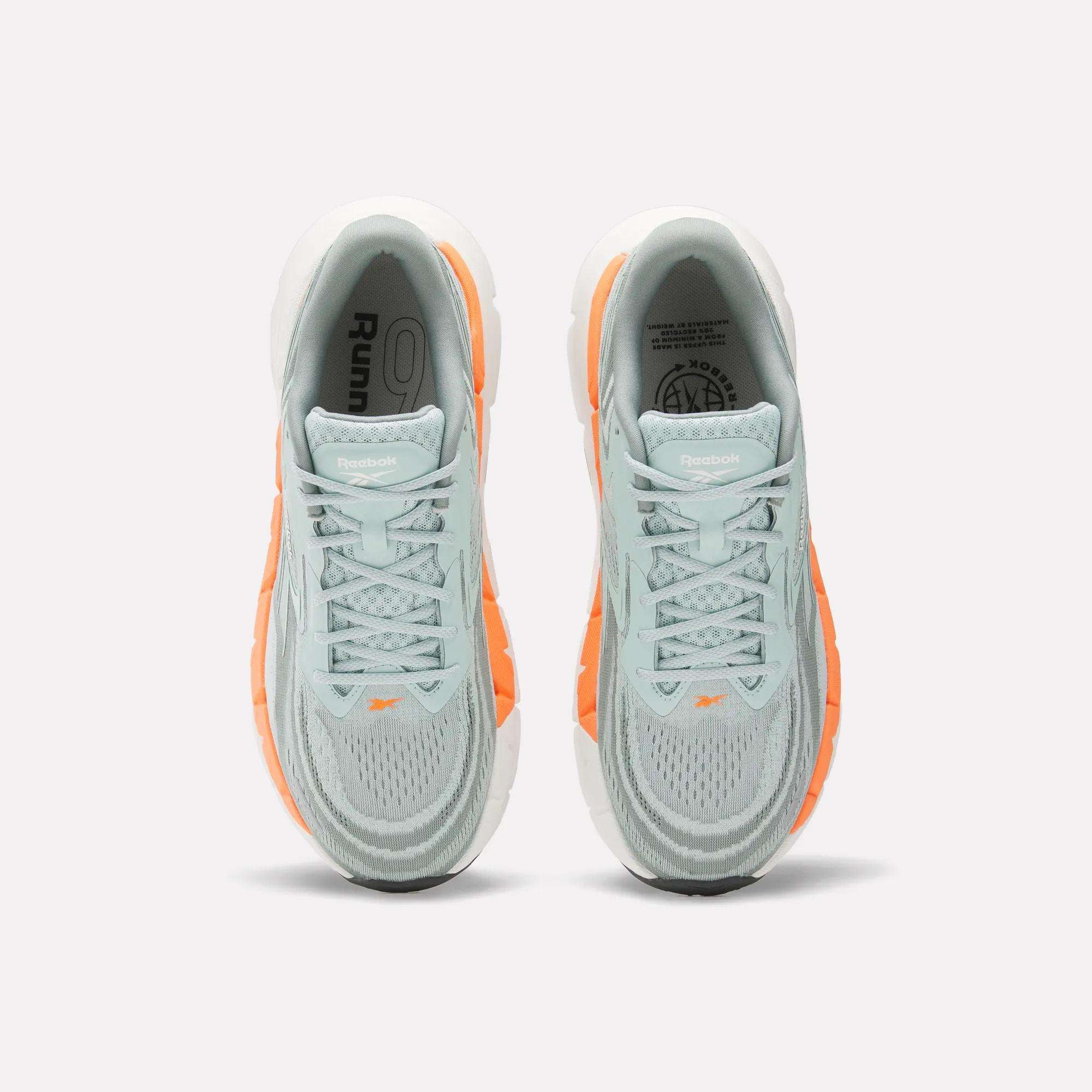 Top view of Reebok Men's FloatZig Double Running Shoes in light blue and gray with orange accents, white soles, and logo on the tongue—ideal max-cushion runners set against a light background.