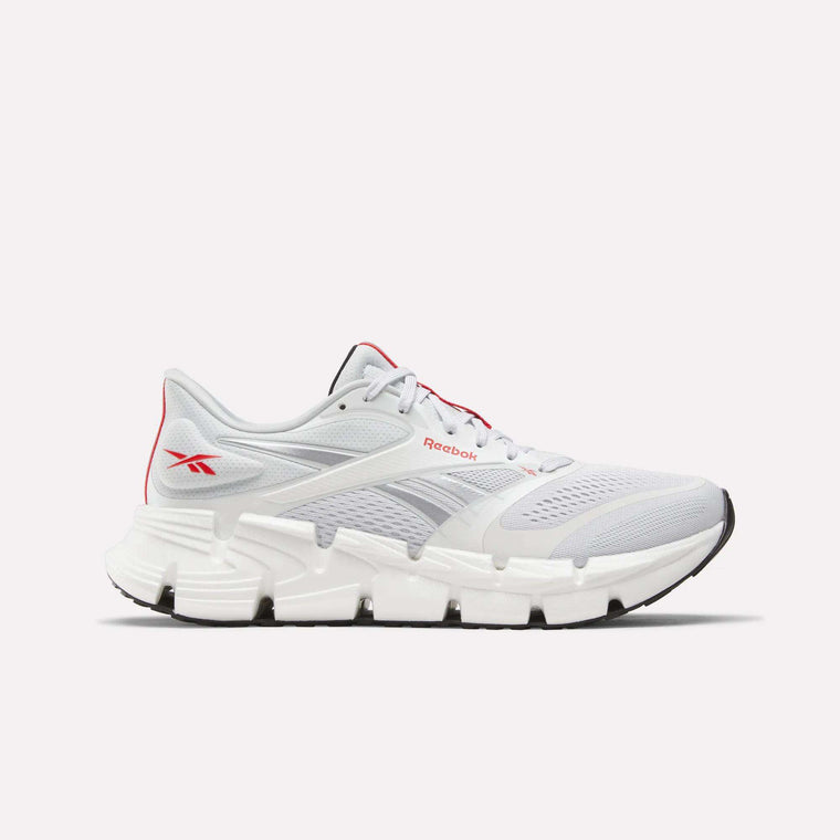 Introducing the Men's FloatZig 2 Running Shoes by Reebok—a white running shoe featuring gray and red accents, a breathable mesh upper, and a chunky white sole with black detailing enhanced by Superfloat+ cushioning. Pictured from the side on a plain background, these shoes are ideal for men seeking top-tier comfort and performance in their running footwear.