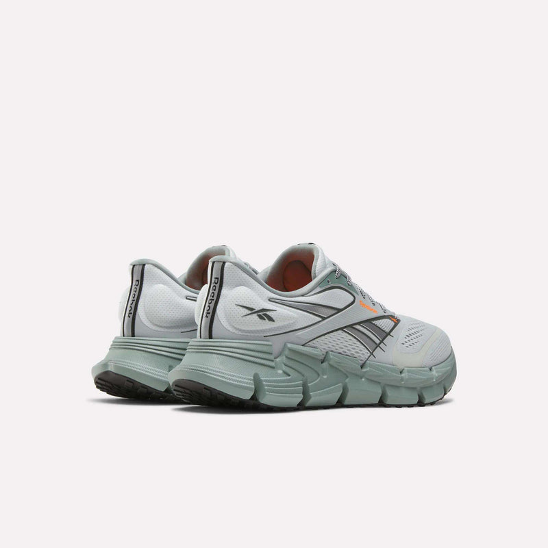 A pair of Reebok Men's FloatZig 2 Running Shoes in light gray and mint green, featuring a supportive upper, thick textured soles, side stripes, and Reebok logos on the heel and side, displayed on a plain white background.