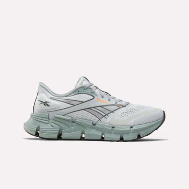 The Reebok Men's FloatZig 2 Running Shoes feature light gray and mint green colors, a chunky segmented sole with Superfloat+ cushioning, black line accents, a supportive upper, and the signature Reebok logo on the side.