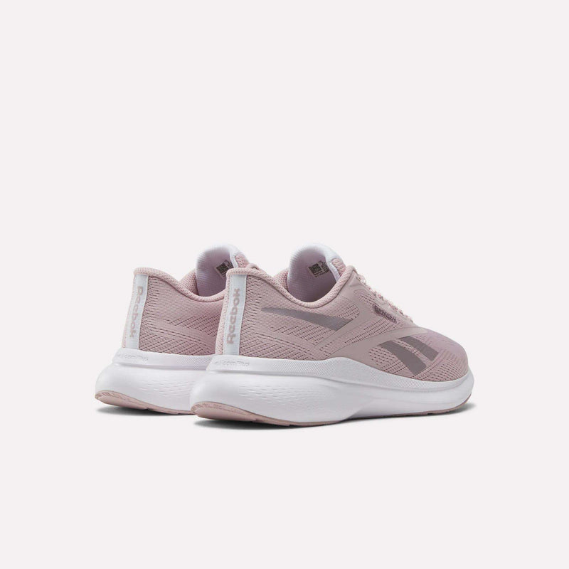 The Reebok Women's Energen Run 4 Running Shoes in light pink feature a breathable mesh upper and white soles, shown from back and side angles against a plain white background.