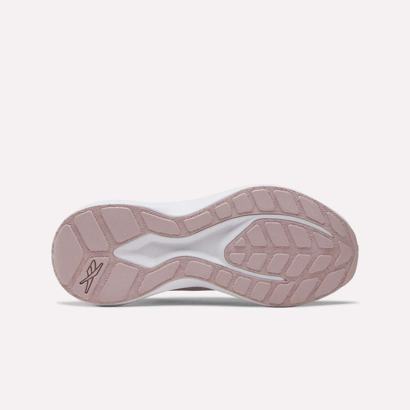 The image shows the bottom view of Reebok Women's Energen Run 4 Running Shoes with a textured, light pink and white rubber sole featuring a geometric tread pattern and a small Reebok logo near the heel.
