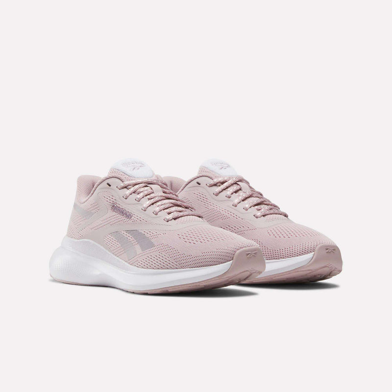 The Women's Energen Run 4 Running Shoes by Reebok feature a light pink mesh upper, white soles, and laces, showcased against a plain white background.