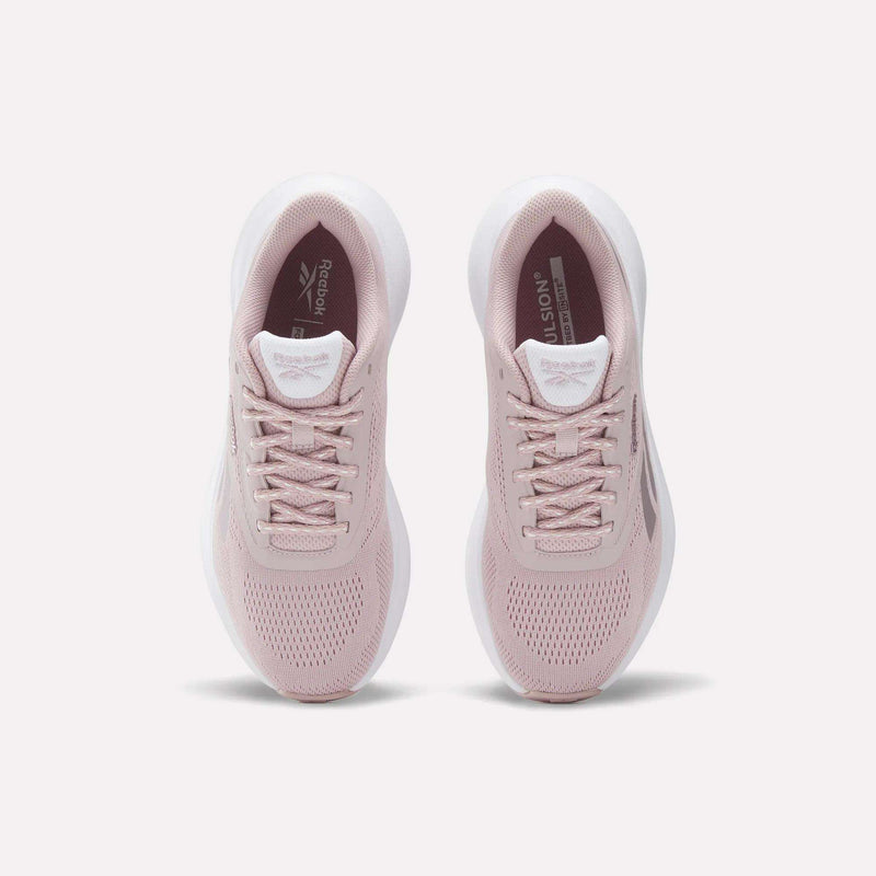 A pair of Women's Energen Run 4 Running Shoes by Reebok in light pink with white soles, viewed from above on a plain white background. These lightweight shoes have a breathable mesh upper, laces, and Reebok branding on the tongue and insole.