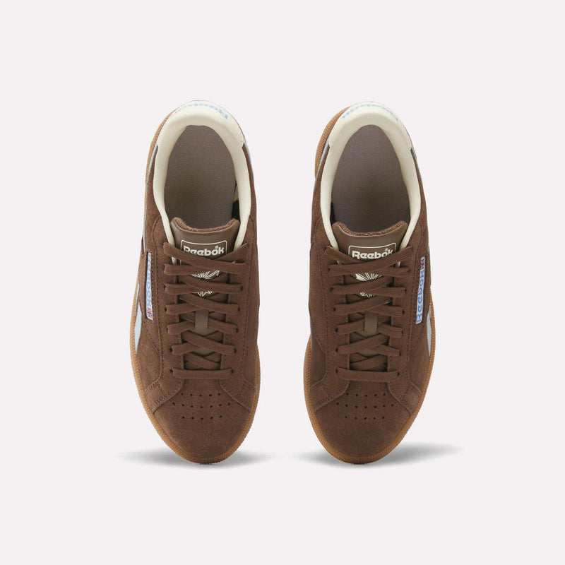 A top-down view of Reebok Women's Club C Grounds UK Shoes in brown, featuring laces, perforated toes, and white side logo accents against a plain white background.