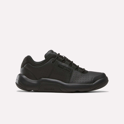 The Reebok Dmx Comfort + Classic sneaker in Black/Black features a low-profile design, perforated sides, premium leather construction, lace-up closure, and a thick rubber sole, displayed on a plain white background.