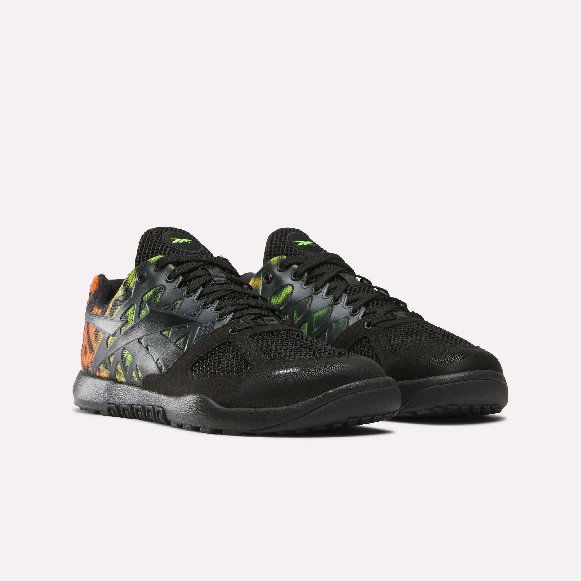 A pair of Men's Nano 2.0 Training Shoes by Reebok in black with mesh uppers, green and orange geometric side patterns, black laces and soles—designed for functional fitness—displayed on a plain white background.