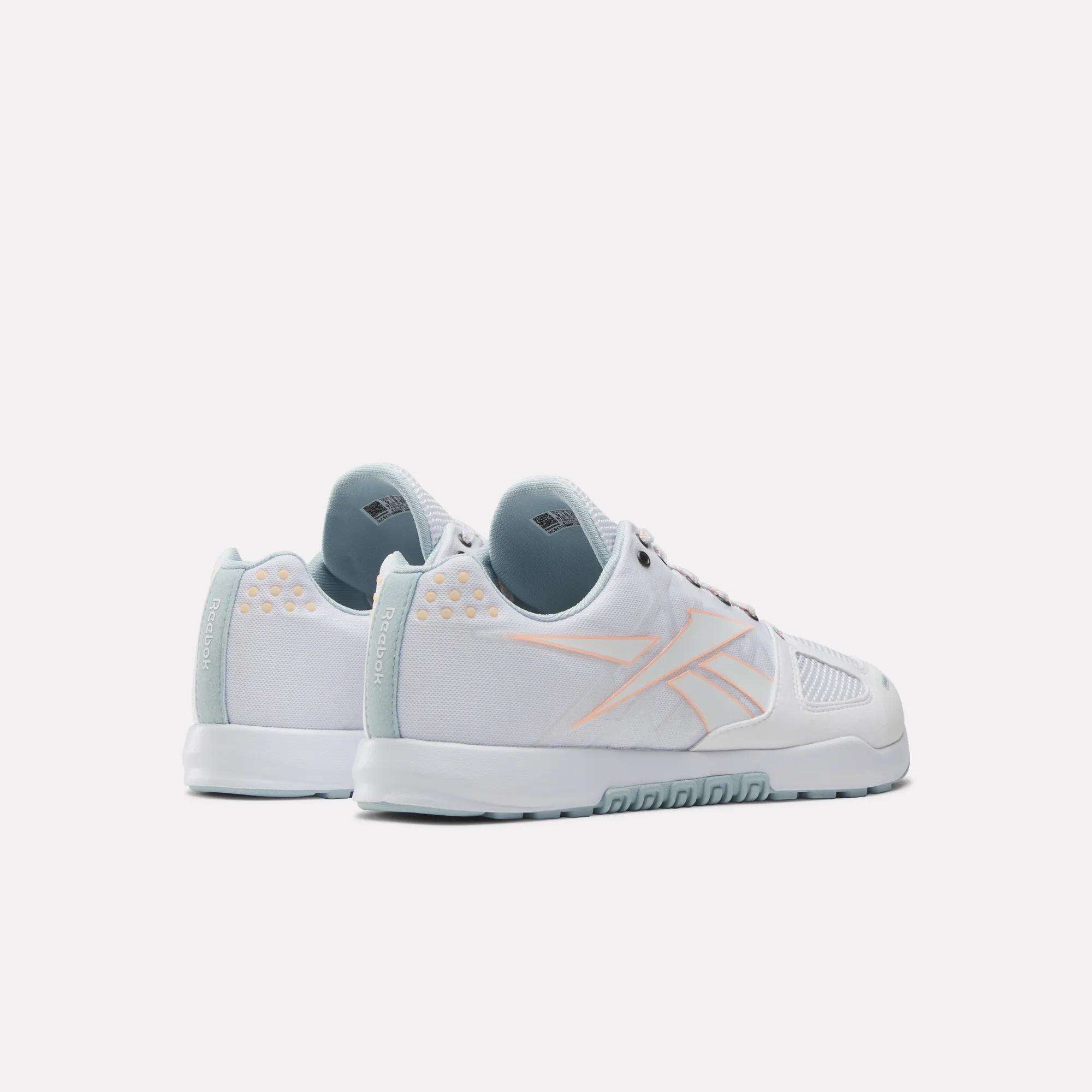 The Reebok Men's Nano 2.0 Training Shoes in white with light blue soles and accents, plus a pale orange logo outline on the side, ideal for functional fitness, are shown against a plain white background.
