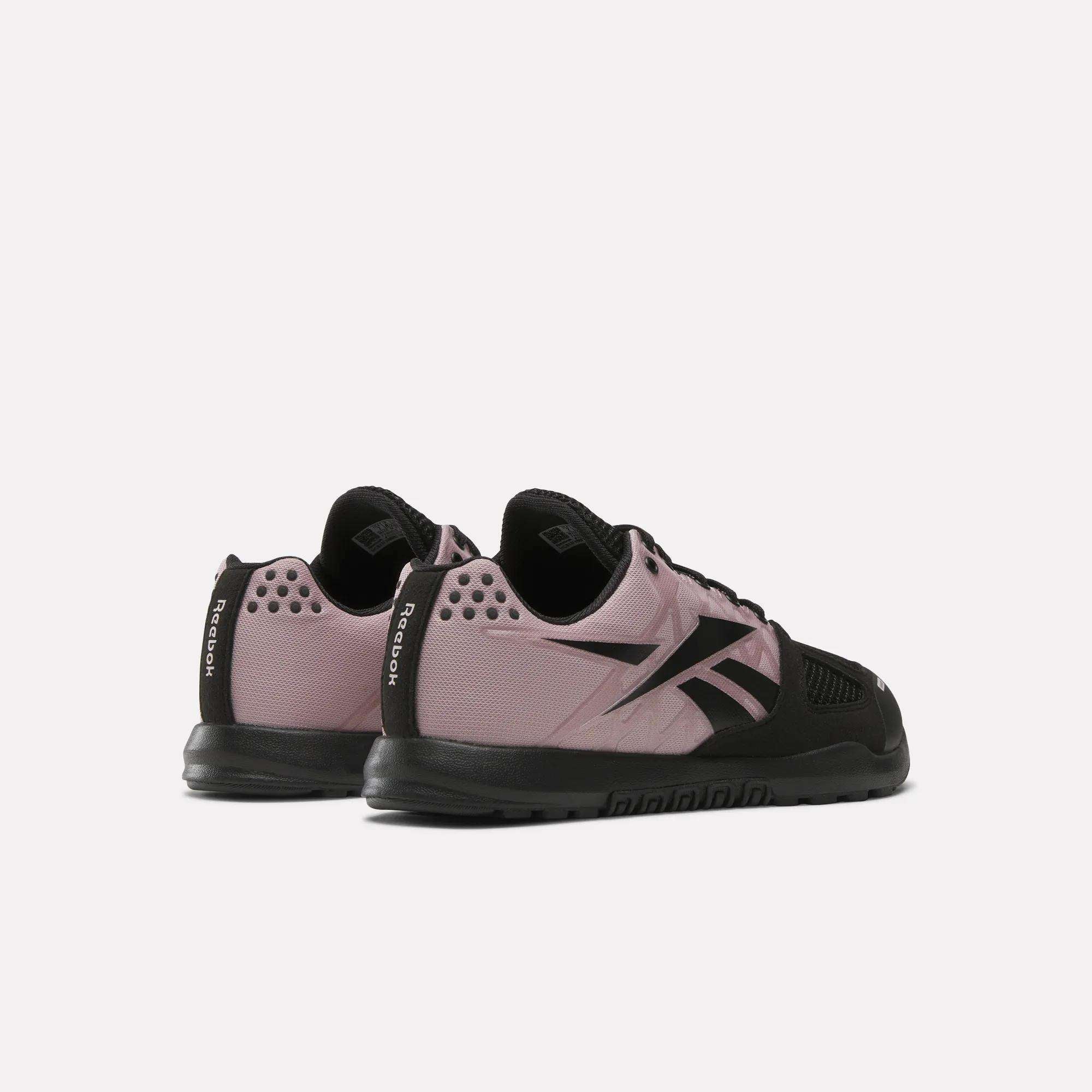 Reebok Women's Nano 2.0 Training Shoes in mauve and black are displayed on a light background with the heels angled together, showcasing their side and rear design—perfect for women's functional fitness routines.