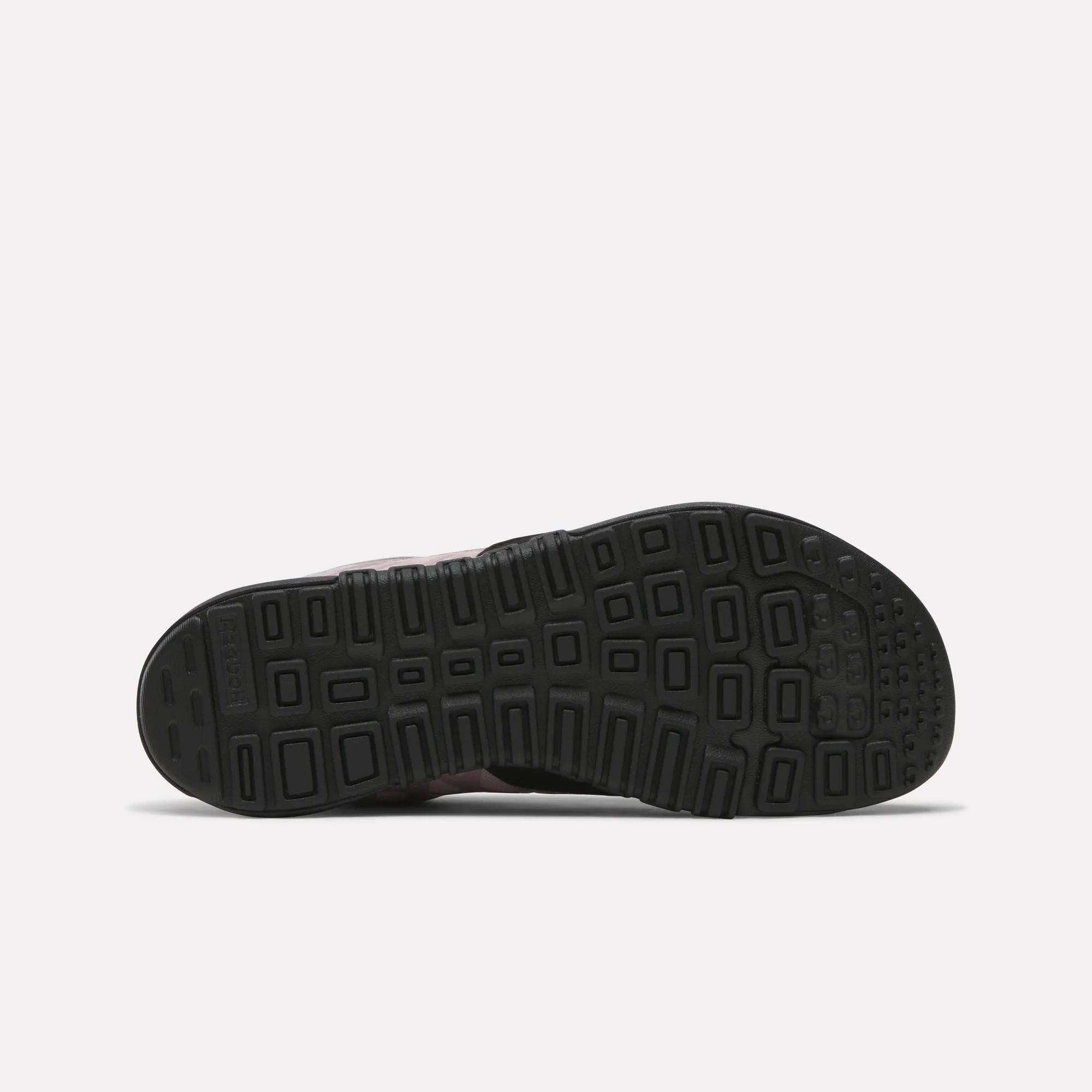 The image displays the black rubber sole of Reebok Women's Nano 2.0 Training Shoes, featuring a geometric tread pattern with squares and rectangles. The shoe is shown sole up on a plain light background—ideal for functional fitness.
