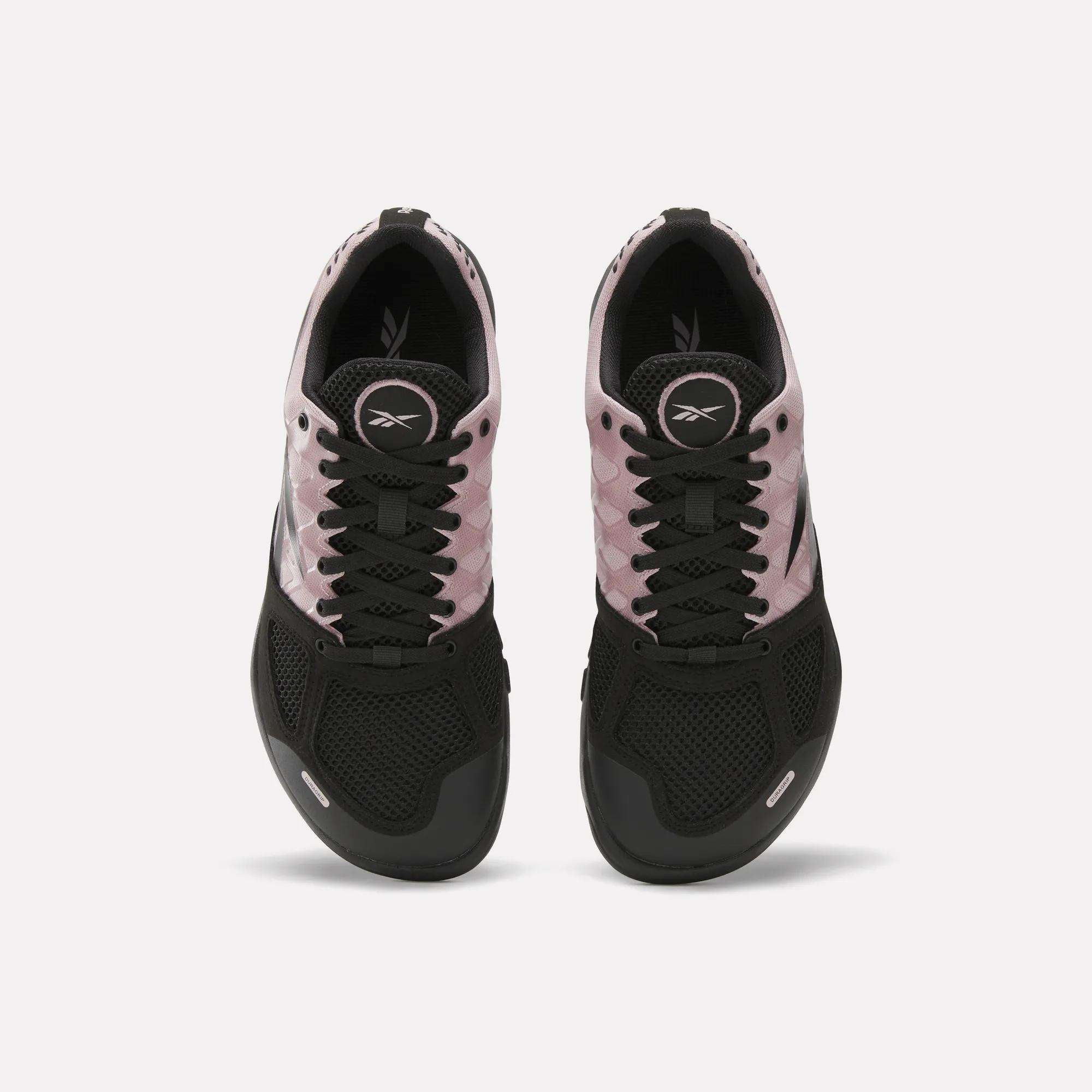 The Reebok Women's Nano 2.0 Training Shoes are shown from above with black mesh toes, black laces, light pink sides, and visible Reebok logos on the tongue and insole—ideal women's training shoes for functional fitness.
