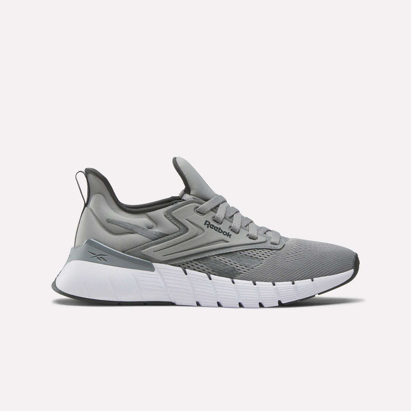 The Reebok Women's Nano Gym Training Shoes feature a gray mesh upper, laces, and a cushioned white and black sole with subtle side branding. Shown on a plain white background, they're perfect for fitness enthusiasts and cross-training.