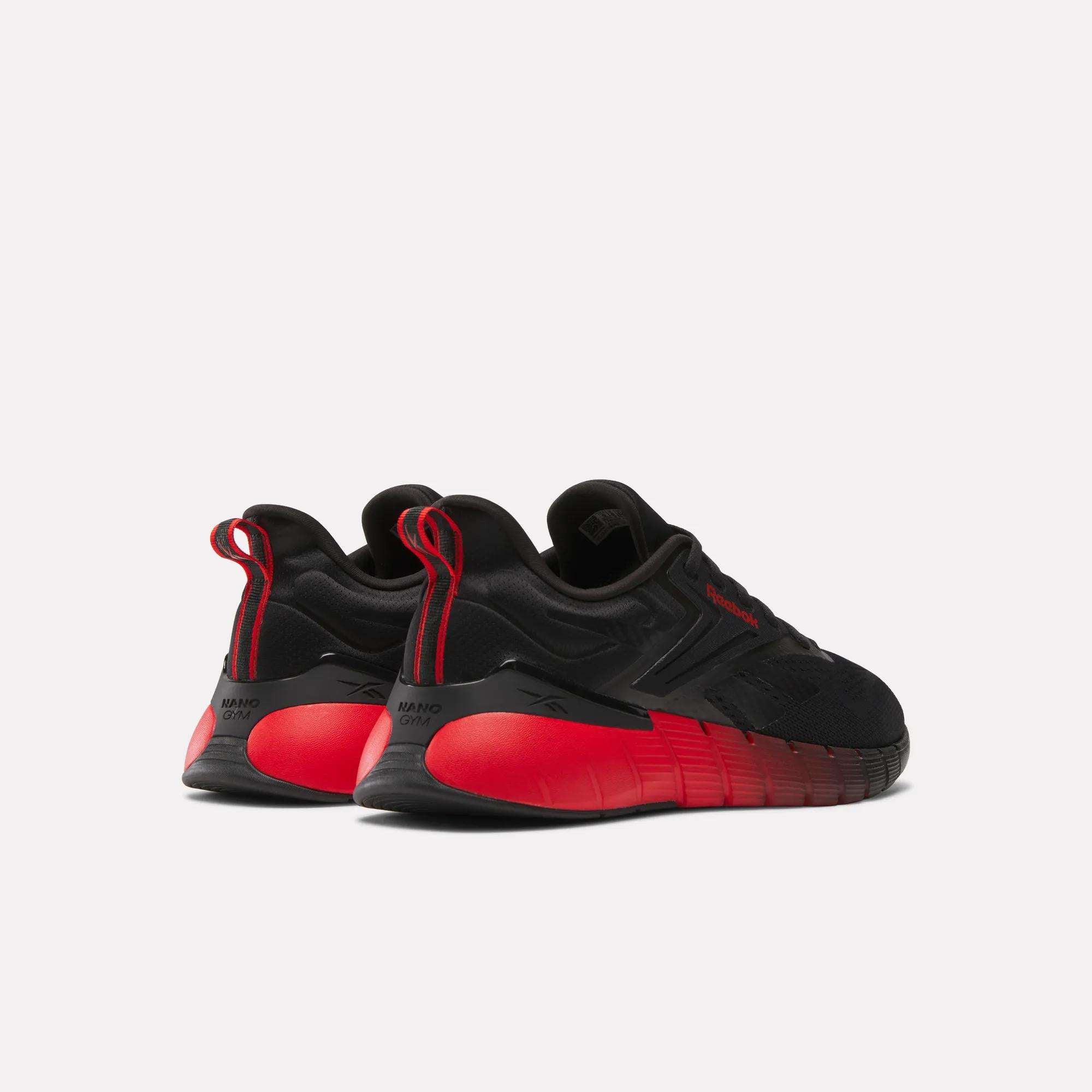 A pair of Reebok Men's Nano Gym Training Shoes in black with thick red soles and red accents on the heel and sides, viewed from the back and slightly to the side against a plain white background.