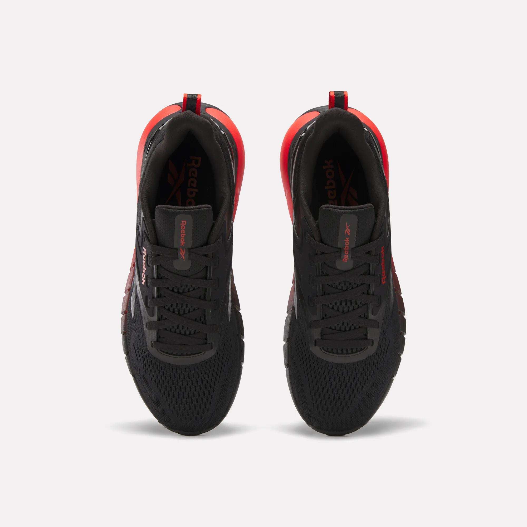 Top view of Reebok Men's Nano Gym Training Shoes in black with red accents and white midsoles, placed side by side on a white background.