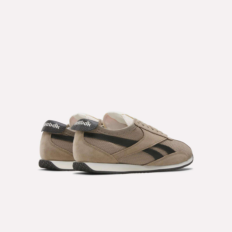 Beige Reebok R400 Shoes with black stripes and heel tabs, shown from the side and slightly behind on a white background, showcase vintage running style.