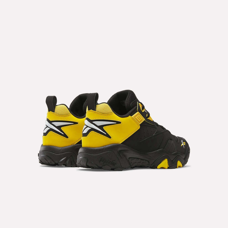 The Brutus Low Shoes by Reebok feature black and yellow colorways, chunky soles, and bold white Reebok logos on the heels, delivering street-ready style against a clean white background.