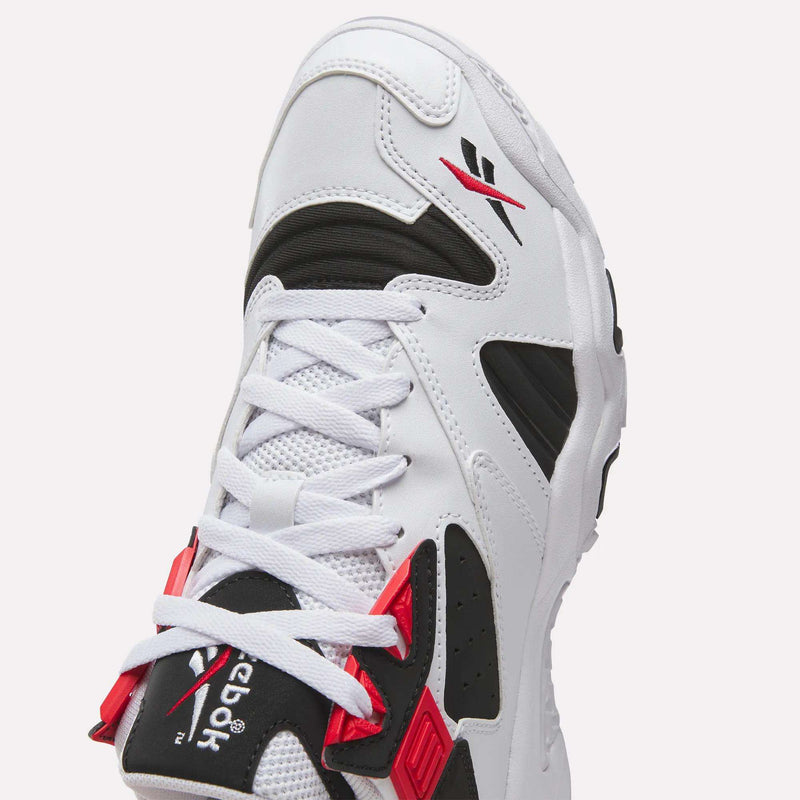 A close-up of the Reebok Brutus Low Shoes, white with black and red accents, showcases the Reebok logo on the tongue and a distinctive lace design for street-ready style.
