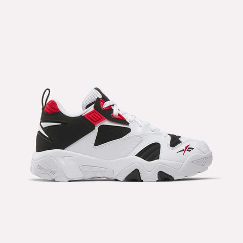 The Reebok Brutus Low Shoes are white athletic sneakers with black and red accents, featuring a chunky sole, mesh and synthetic overlays, signature logos, low-top design, and white laces for heritage style with street-ready appeal.