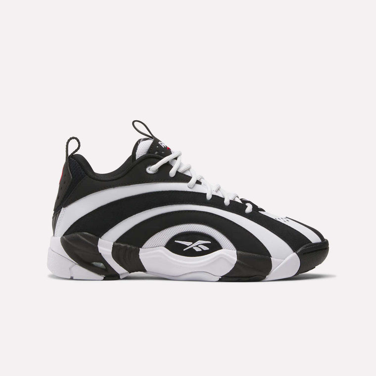 The Reebok Shaqnosis Low Shoes feature bold black and white wave patterns, white laces, and Reebok logos on the side and tongue. They offer Hexalite cushioning for comfort and are shown on a plain white background.