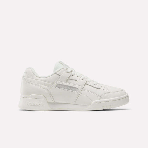 The Reebok Women's Workout Plus Shoes feature a low-top white design with a perforated toe box, side stitching, lace-up front, and classic Reebok branding—ideal for versatile women's fitness routines. Shown against a plain light background.