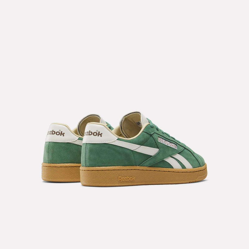 The Reebok Club C Grounds UK Shoes feature green premium suede, white accents, and gum soles, displayed from side and back angles on a plain white background for a classic look.