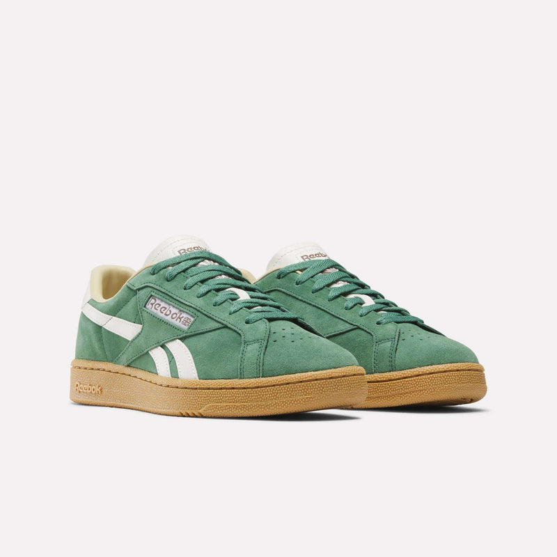 A pair of Reebok Club C Grounds UK Shoes in green, featuring white stripes and logos, a cream-colored interior, premium suede details, and tan rubber soles—shown against a plain white background.