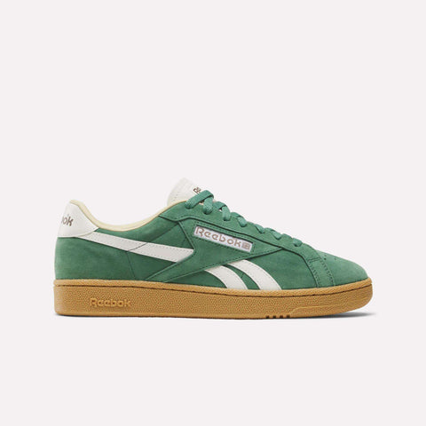 The Reebok Club C Grounds UK Shoes feature a green suede upper with white accents, a white logo, and a tan gum sole, displayed in side profile against a plain white background.