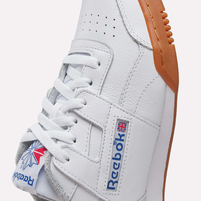 Close-up of Reebok Workout Plus Shoes featuring a white upper, brown gum sole, white laces, and signature Reebok branding with the Union Jack—a classic '80s workout sneaker.