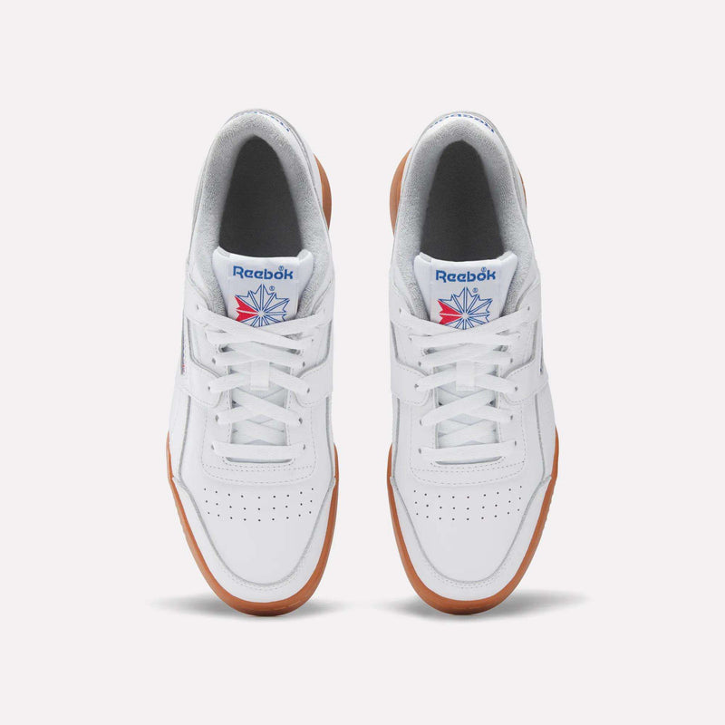 A pair of Reebok Workout Plus Shoes in white with gum soles, seen from above. Featuring white laces, perforated toe boxes, and the classic Reebok logo with blue and red accents on the tongues—an iconic '80s fitness look.
