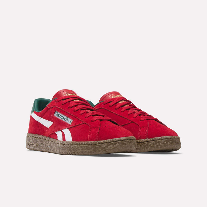 The Reebok Club C Grounds UK Shoes feature red uppers, white stripes, green inner lining, and brown rubber soles—classic tennis style sneakers displayed on a plain white background.