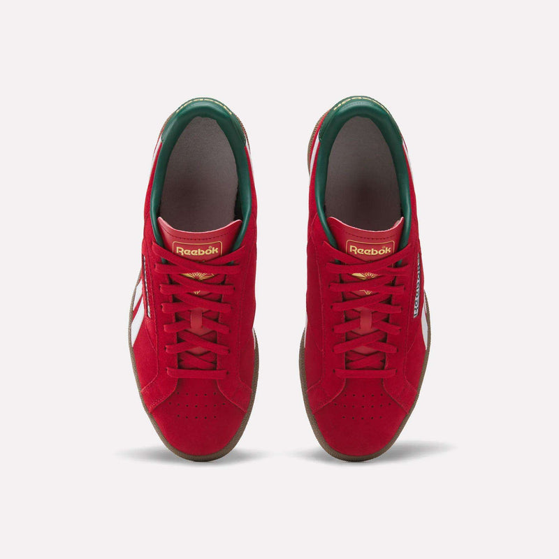 Top view of a pair of Reebok Club C Grounds UK Shoes in red with white side stripes, green inner lining, and gold branding on the tongue, displayed side by side on a white background—classic tennis-inspired casual style.